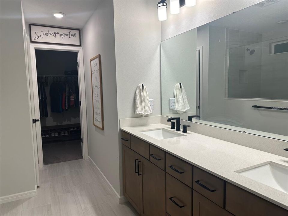 bathroom with dual sink vanity, super shower, private toilet area, and walk in closet