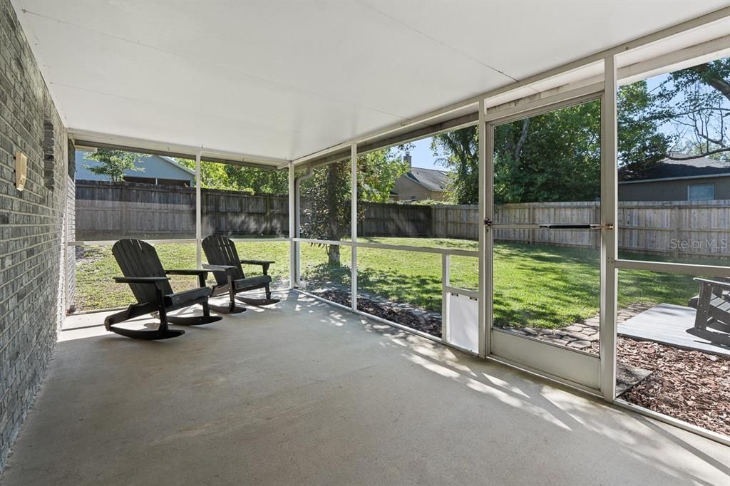 Covered screened in lanai  with the view of the back yard.