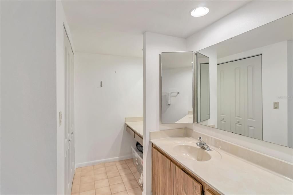 Vanity and storage/ linen closet space in the primary bathroom