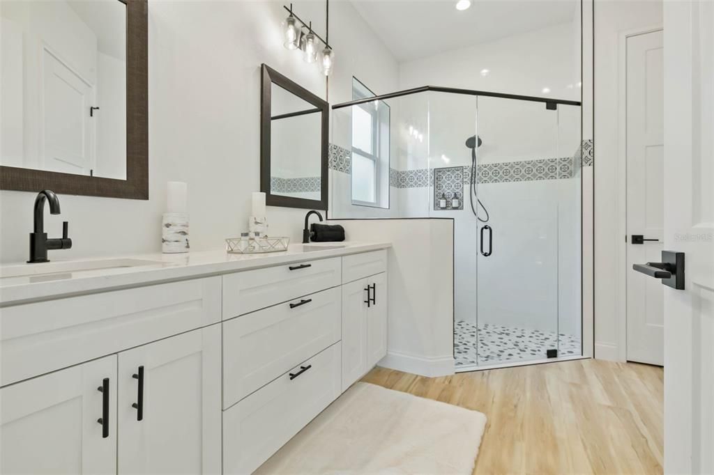 Owners bath with quartz countertops, custom mirrors and oversized walk in shower.