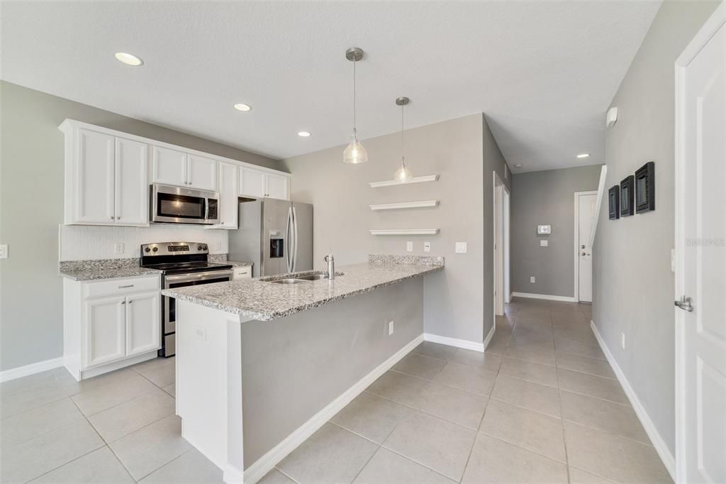 Follow the natural flow into the kitchen any home chef will love featuring GRANITE COUNTERS, stainless steel appliances, pantry for ample storage and BREAKFAST BAR SEATING under pendant lighting for casual gatherings!