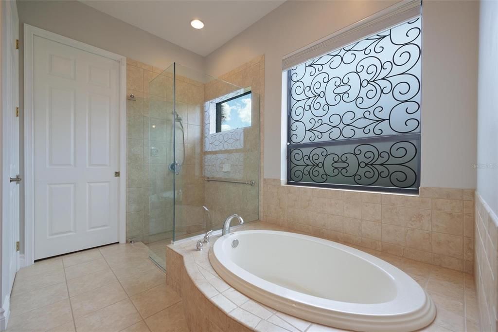 View of the garden tub and walk in shower with glass surround in Owner's Bathroom.