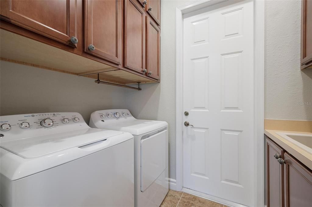 Off the Kitchen is the Laudry room with wood cabinetry that fills the space to the ceiling as well as a laundry tub for use. Exterior door leads to the 2 car garage.
