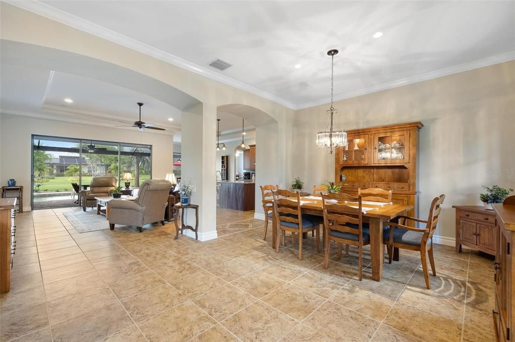 This is the breathtaking view from the front entry. Your eye is immediately drawn to the pool deck and beyond to the greenspace of the back yard. Formal Dining Room, Kitchen, and Living Room have an open and airy flow.