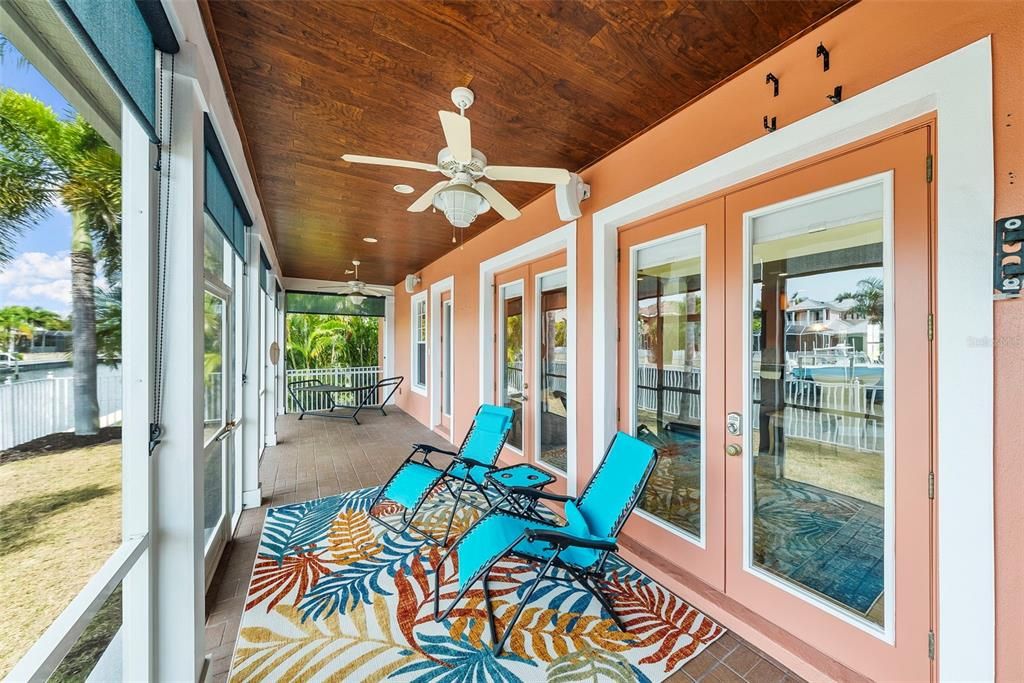 Covered & Screened Patio with gorgeous wood ceiling. Fans  and recently installed custom shades create the perfect place for summer days.