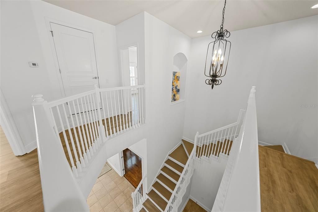 Classic center staircase features wood flooring and white wood banisters leads to the second floor.