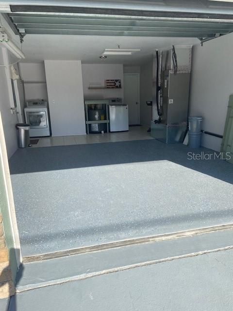 Oversized one car garage with epoxy and tile flooring.