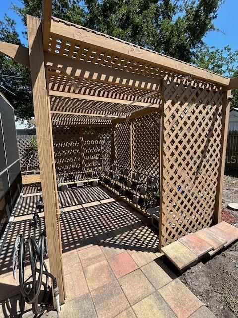Arbor with outdoor shower and water spigot.  Could easily be made into a tiki hut/bar for entertaining.