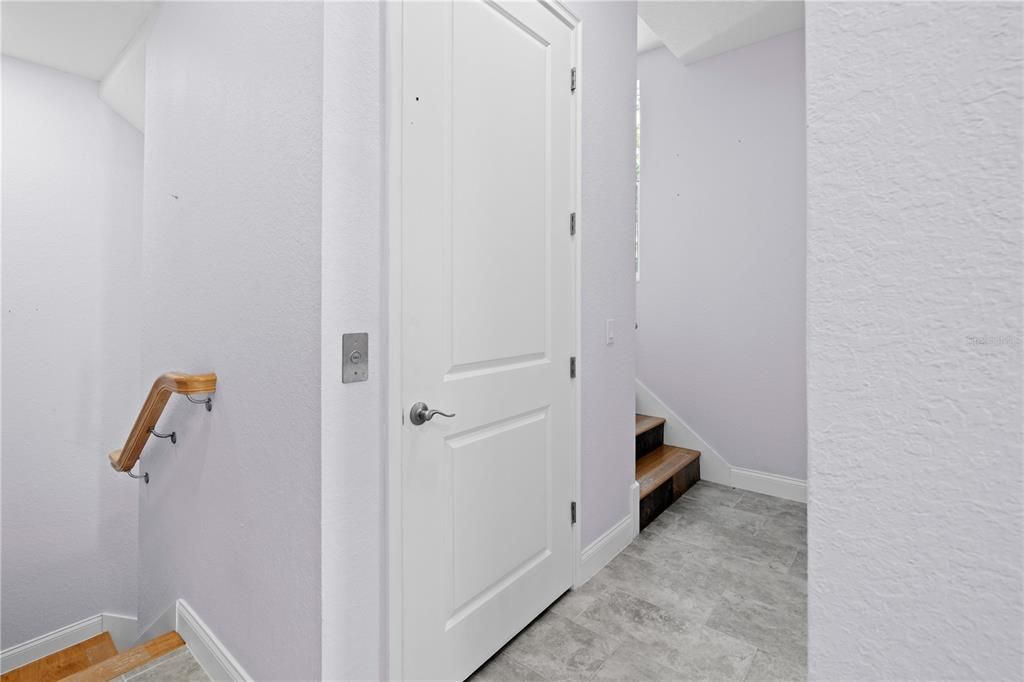 Elevator door is adjacent to the stairs that lead to the three bedrooms on third level.