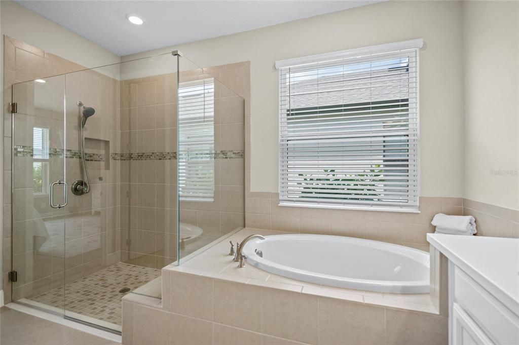 Ensuite Bath with Frameless Enclosed Step-In Shower, Garden Bath, and Dual Vanities