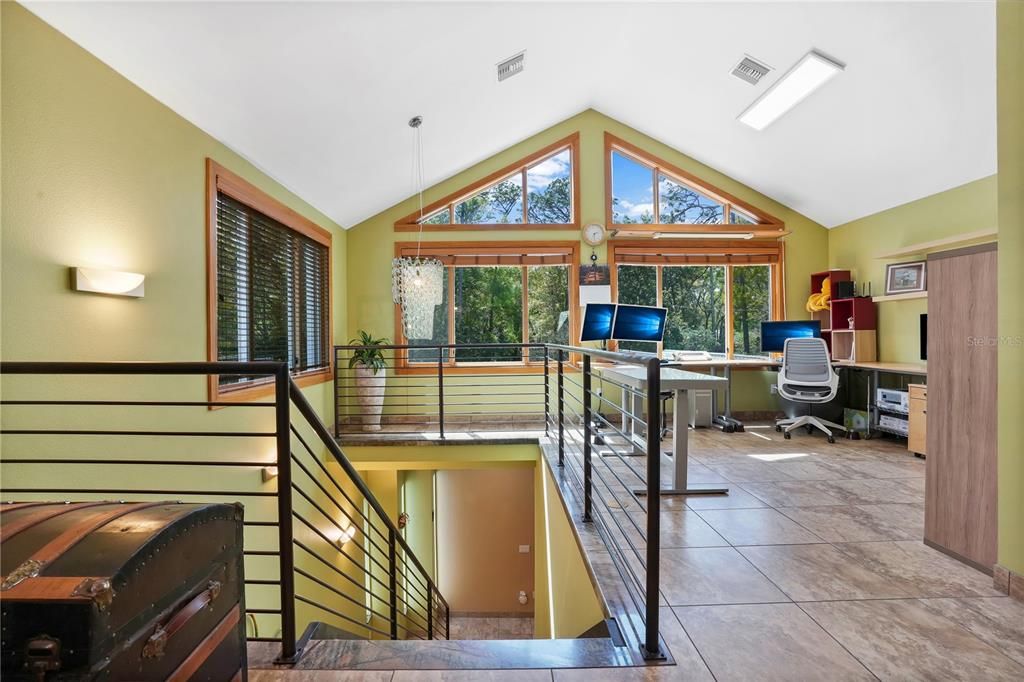 The second floor is highlighted by volume ceilings and architecturally rich triangular windows allowing you to take in all the natural wooded views that this estate has to offer.