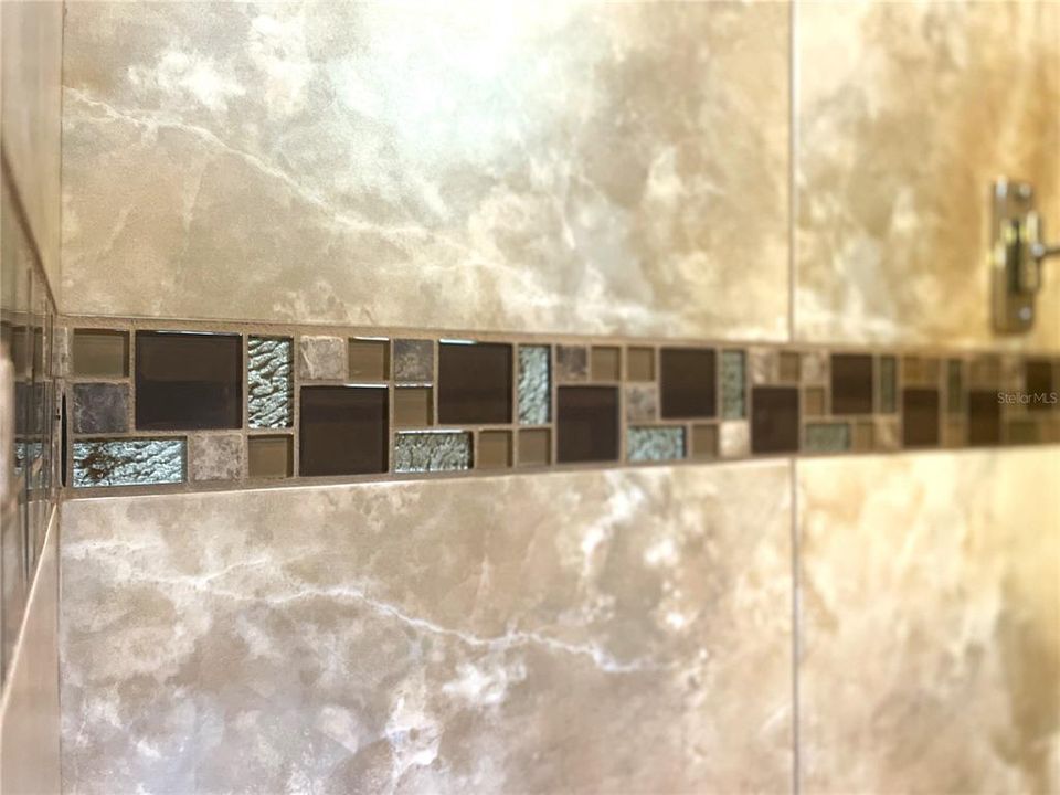 Upgraded glass tile mosaic motif in master bath.
