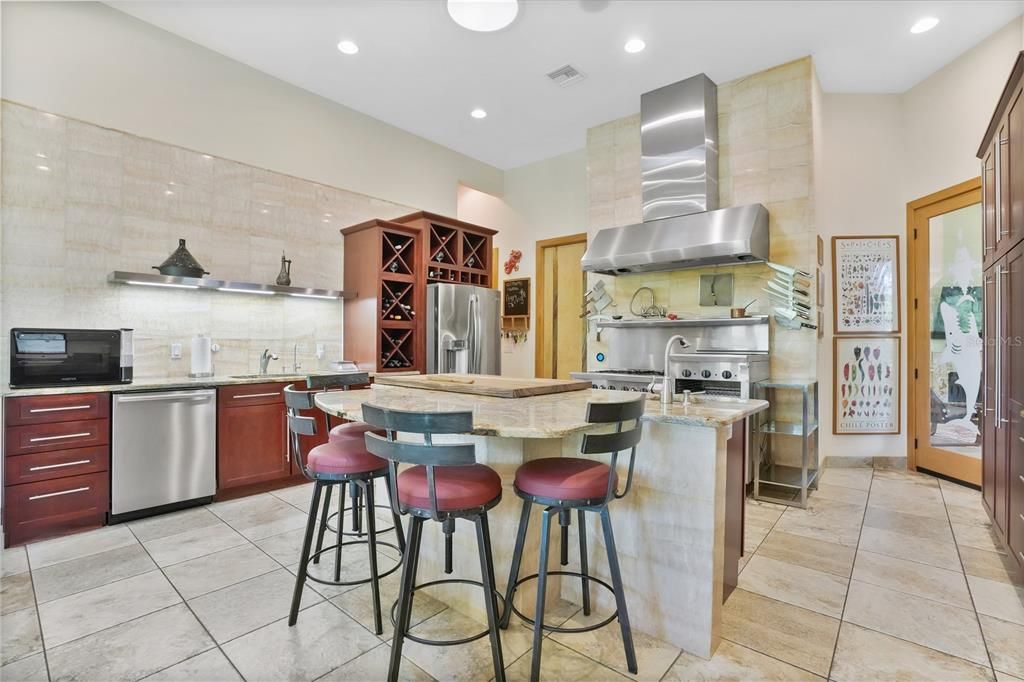 The sink features a custom Onyx backsplash wall and the breakfast bar is the ideal location to serve your guests your favorite culinary creations or to grab a quite bite on the go.