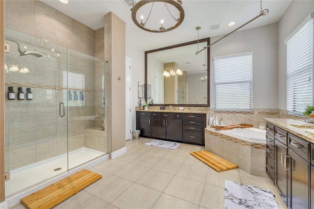 The primary bathroom features duel vanities, a walk in shower and a soaking tub