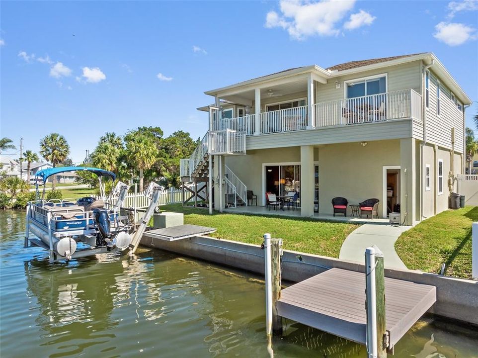 Salt Water Canal, 60 ft concrete seawall, fixed dock w/electricity, outdoor shower, covered patio, upper balcony, exterior staircase, cargo lift up to 1,000 pounds, Fenced in backyard AND a 10,000 POUND BOAT LIFT!!!