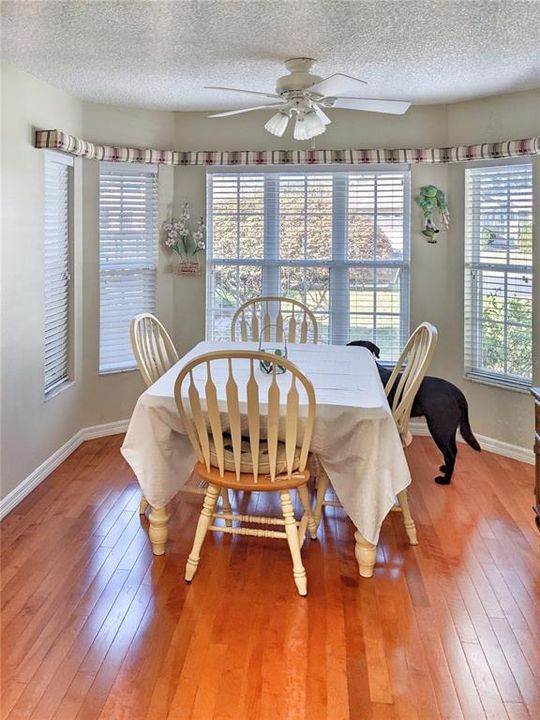 A spacious breakfast nook with a large bay window is a charming spot for casual dining