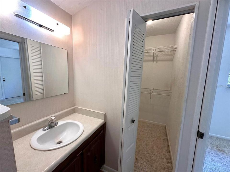 Owners suite sink and door to walk in closet