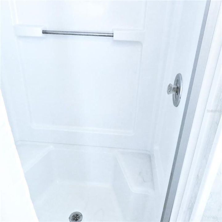Shower with two built in seats and a grab bar