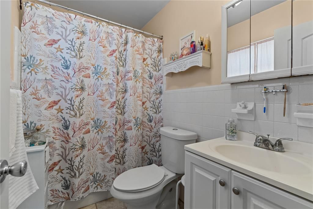 Primary bathroom with single vanity and tile floors