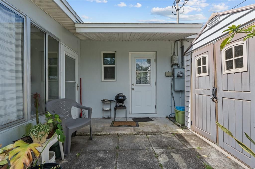 Outdoor barbecue/sitting area that leads to the laundry room and storage shed.