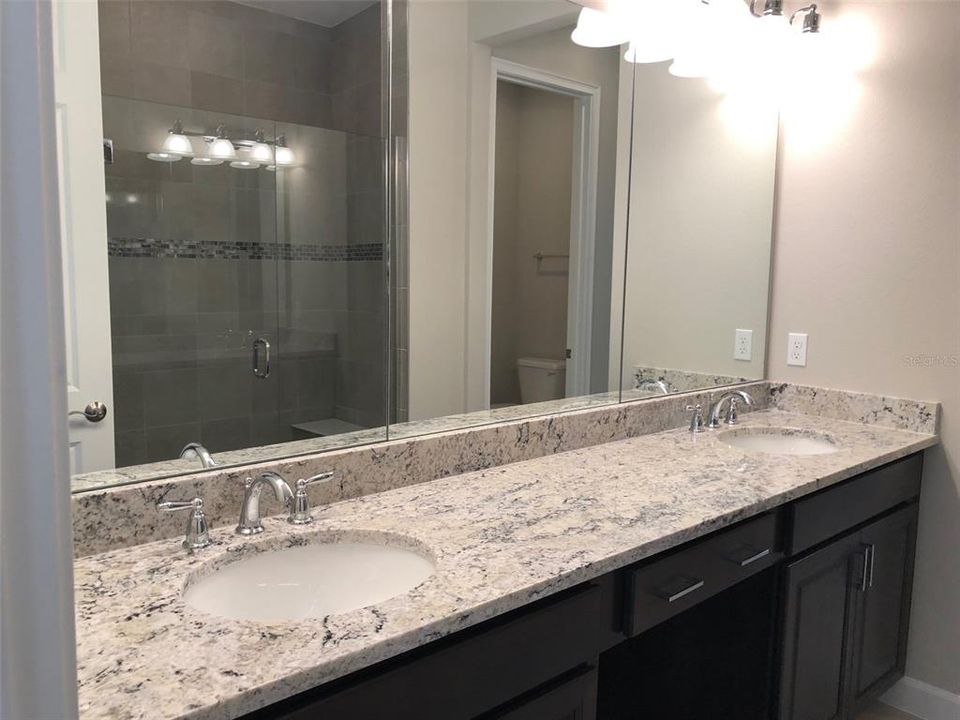 Primary en-suite features beautiful granite counters, under mount dual sinks and beautiful Espresso cabinets.