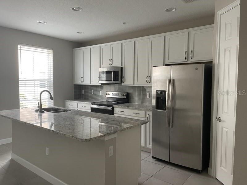Light and bright with granite counters, upgraded cabinets and a beautiful easy to maintain backsplash.