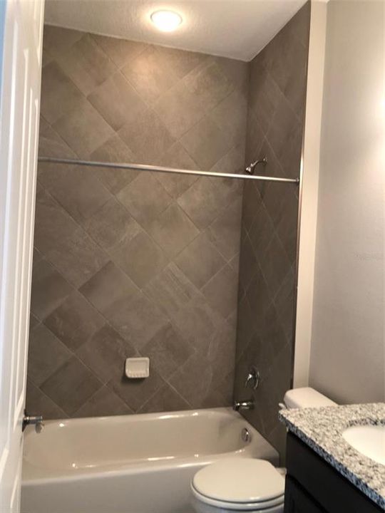 Beautiful custom tiled shower in bedroom 3's private bath.