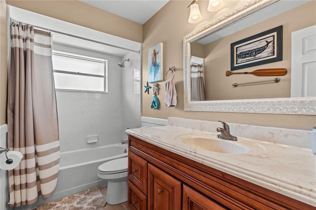 Bathroom #2 has a single vanity, tiled floor and bath tub