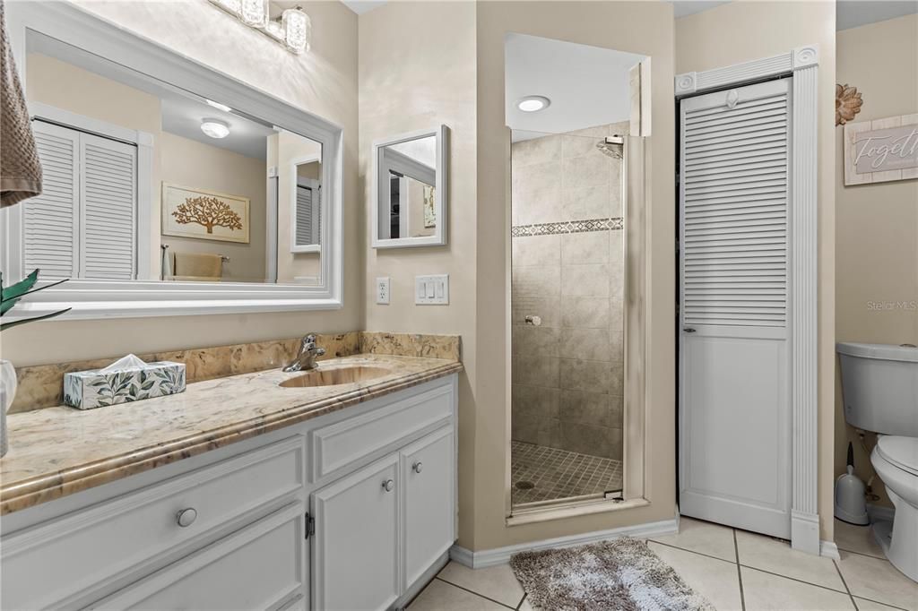 Ensuite bath has single vanity, tiled floors and walk-in shower