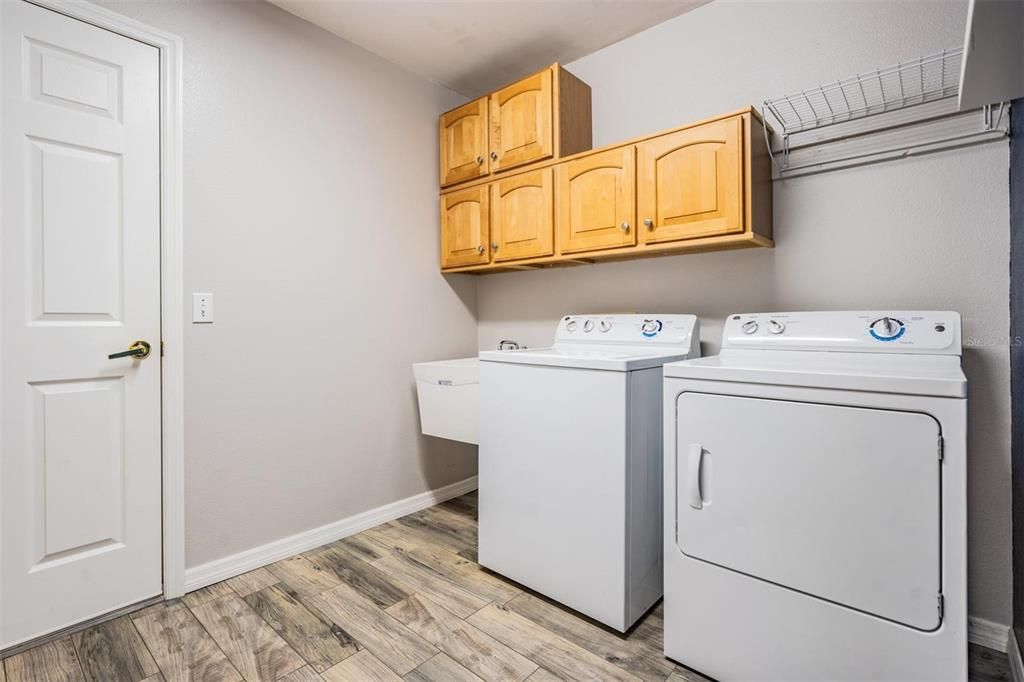 Walk-in laundry room with utility sink and built-in storage options