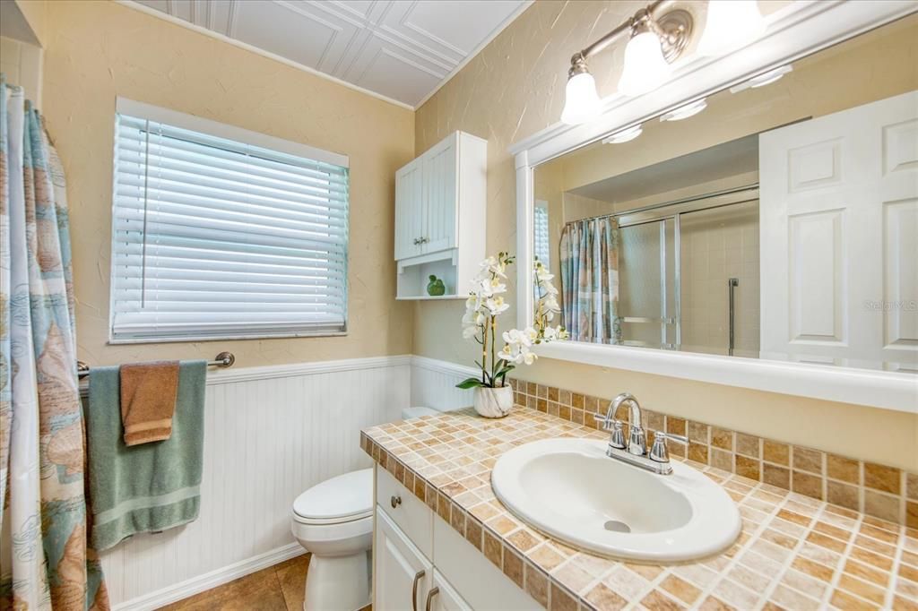 Updated hall bathroom with tub/shower, decorative ceiling and wainscot paneling~