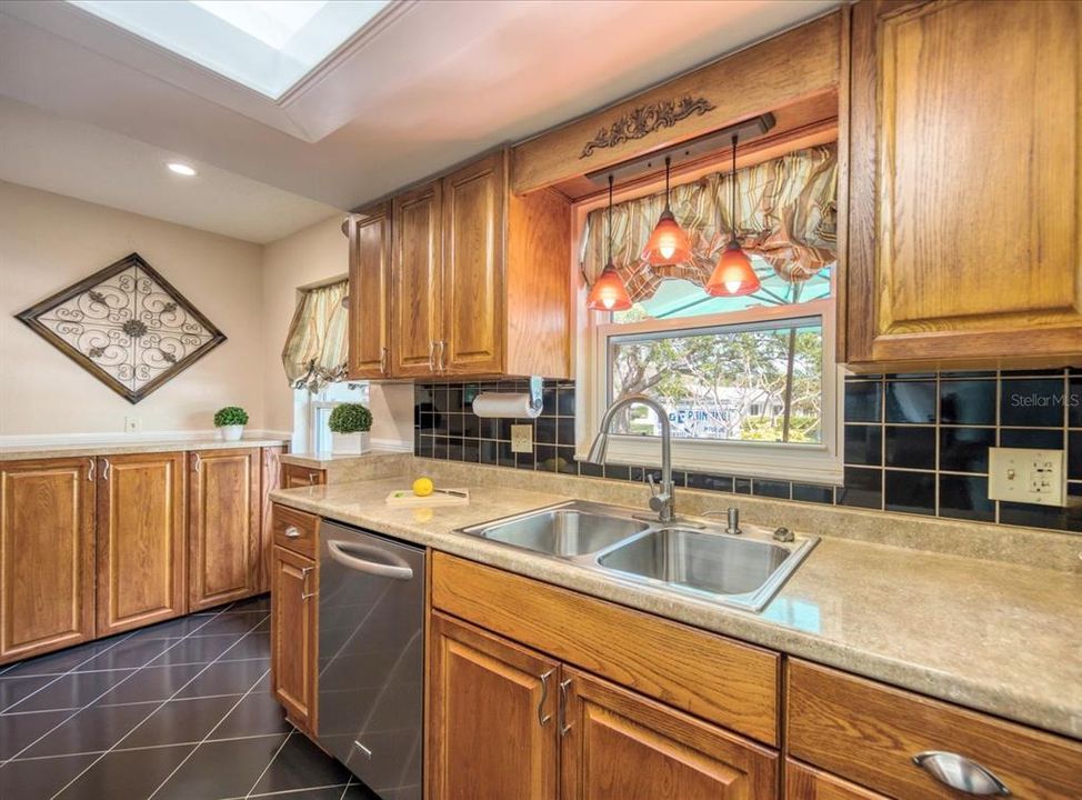 Wood cabinets w/additional cabinet storage & pendant lights at sink window~