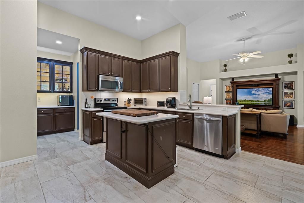 A fluid connection between kitchen and family room featuring bar seating designed for seamless entertaining