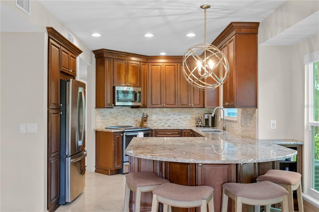 The kitchen has been nicely updated with quartz countertops and a large extended island that can accommodate barstool seating and those hovering around