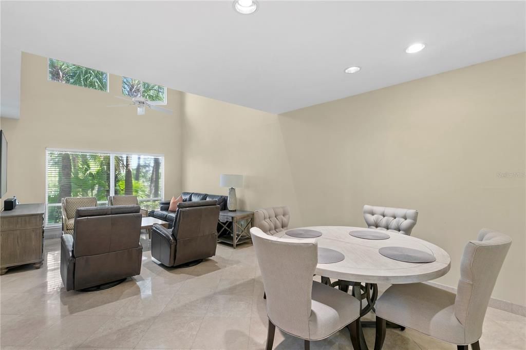 The open dining and living room space with natural light overlooking the lush backyard