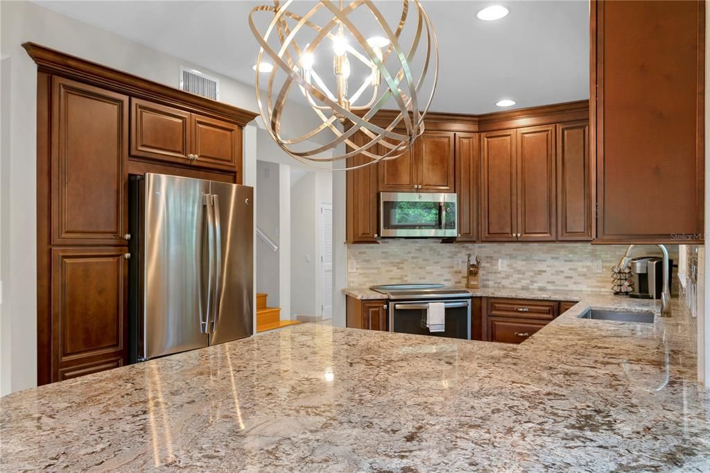 The kitchen has been nicely updated with quartz countertops and a large extended island that can accommodate barstool seating and those hovering around