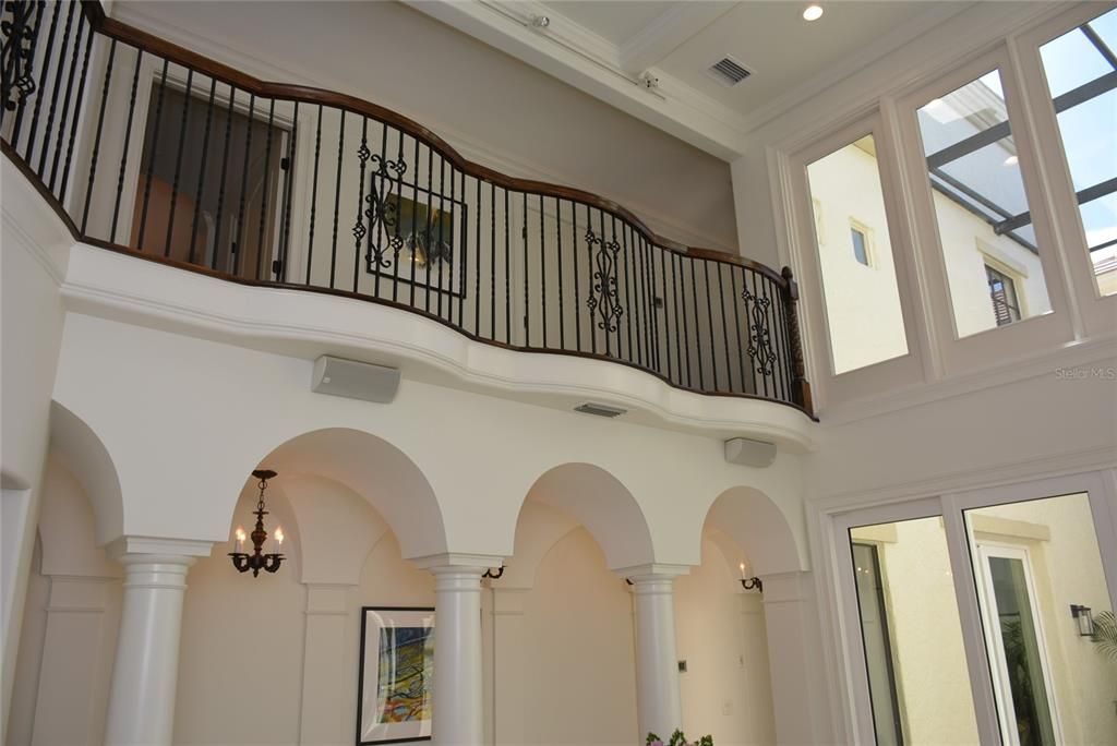 The second level of the staircase opens to an expansive balcony with hardwood floors overlooking  living room & atrium