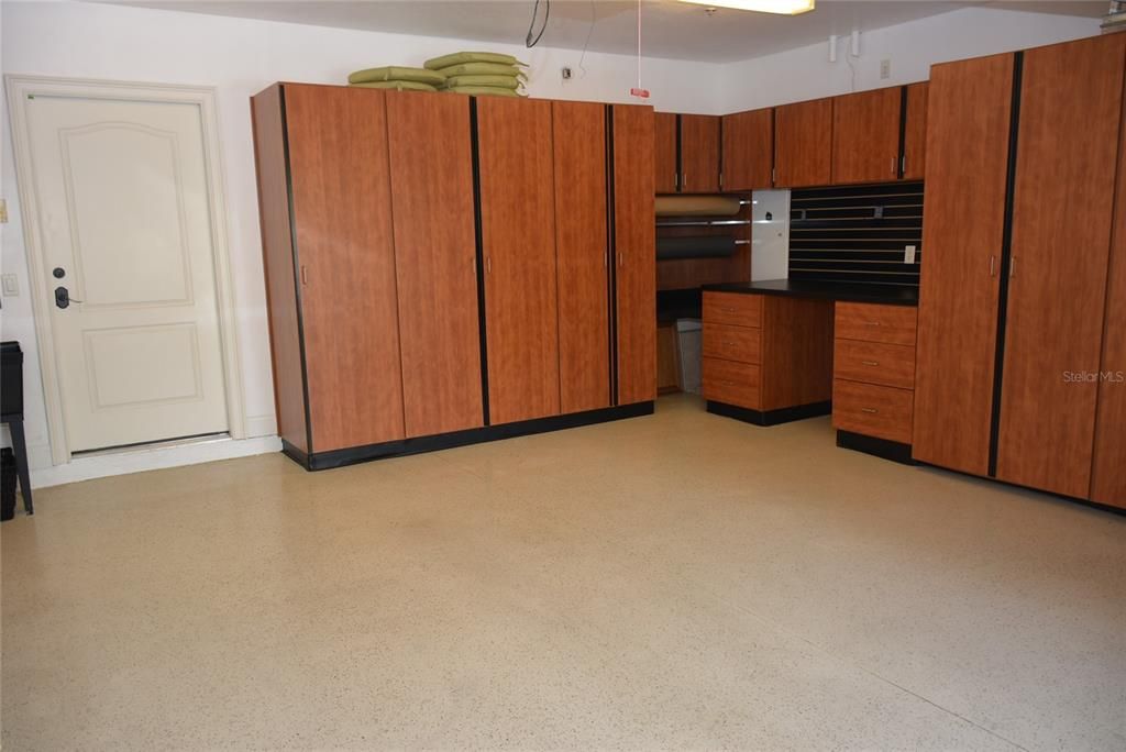 A 2 car garage has epoxy floors, a utility sink and extensive Closets by Design work and storage space