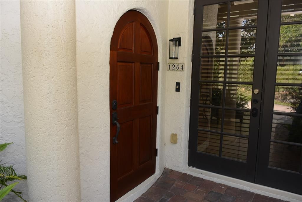 The arched front door opens directly into the foyer with synthetic stone that runs throughout the main level.