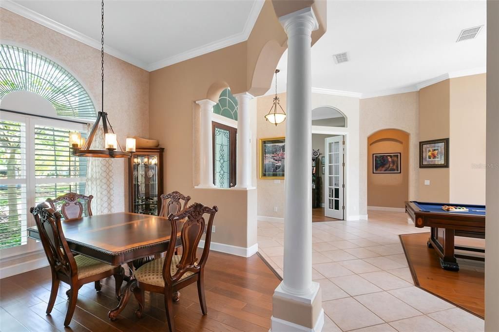 Formal dining with columns and picturesque window