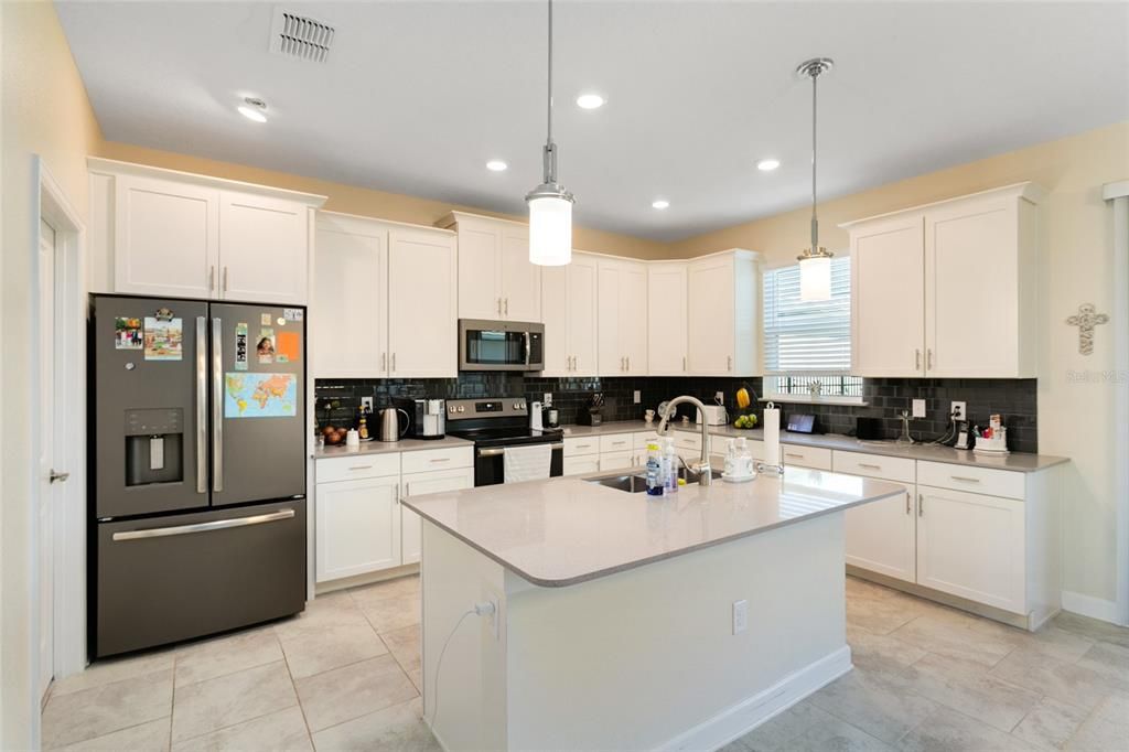 The kitchen was designed with the home chef in mind featuring shaker style cabinetry for ample storage, stylish SUBWAY TILE BACKSPLASH, stainless steel appliances and a large ISLAND with breakfast bar seating - perfect for casual dining with family or entertaining friends!