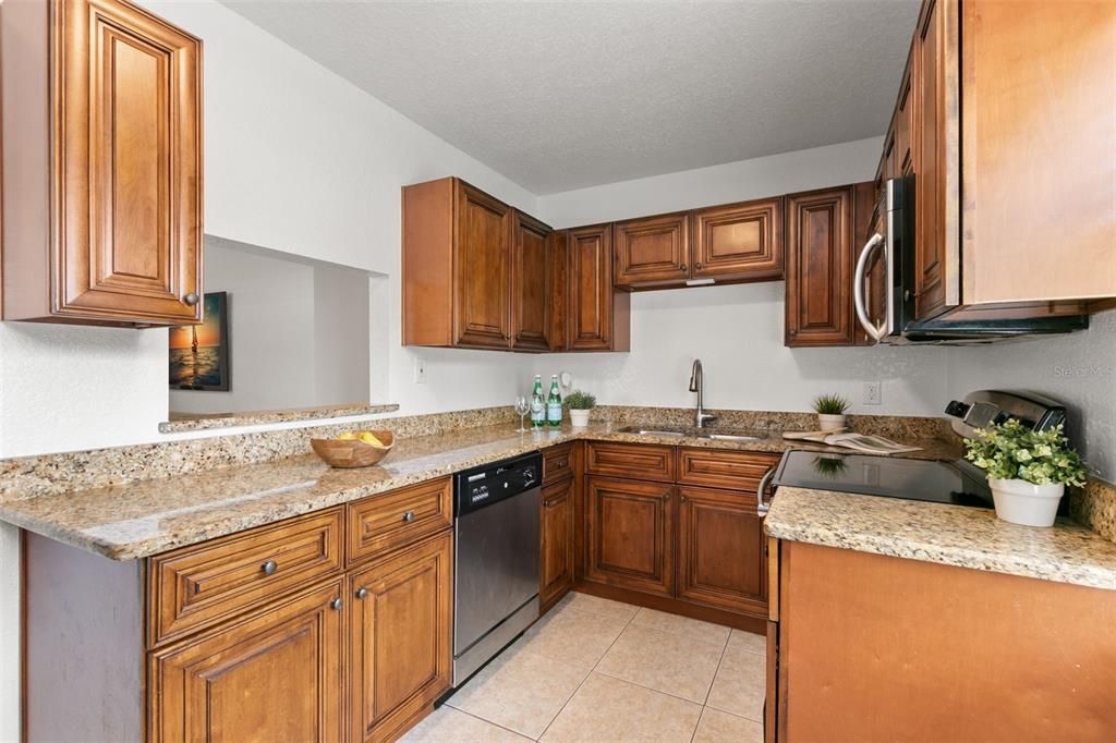 Bright kitchne with wood cabinets and granite counter tops