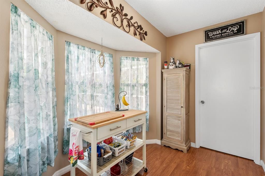 Space just off the kitchen for a little dinette table or perhaps a small home office. The views out the bay windows is the pool. The door leads to the laundry room.