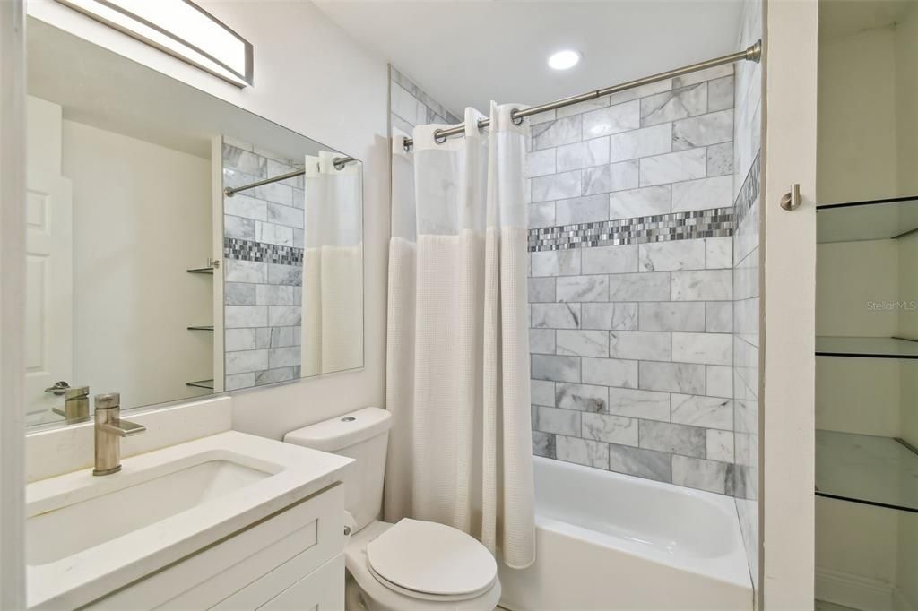 Guest Bathroom w/Marble Tile, Decorative Listello, & Glass Shelving