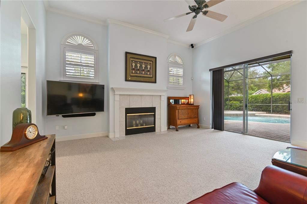 Family Room features a wood burning fireplace and leads into the guest room and Pool Bath with access to the backyard