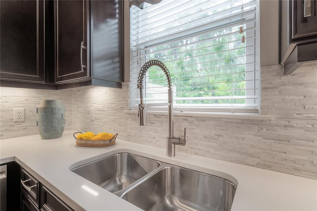 Farmer pull-out spray faucet and textured marble surface staggering stacked tile backsplash