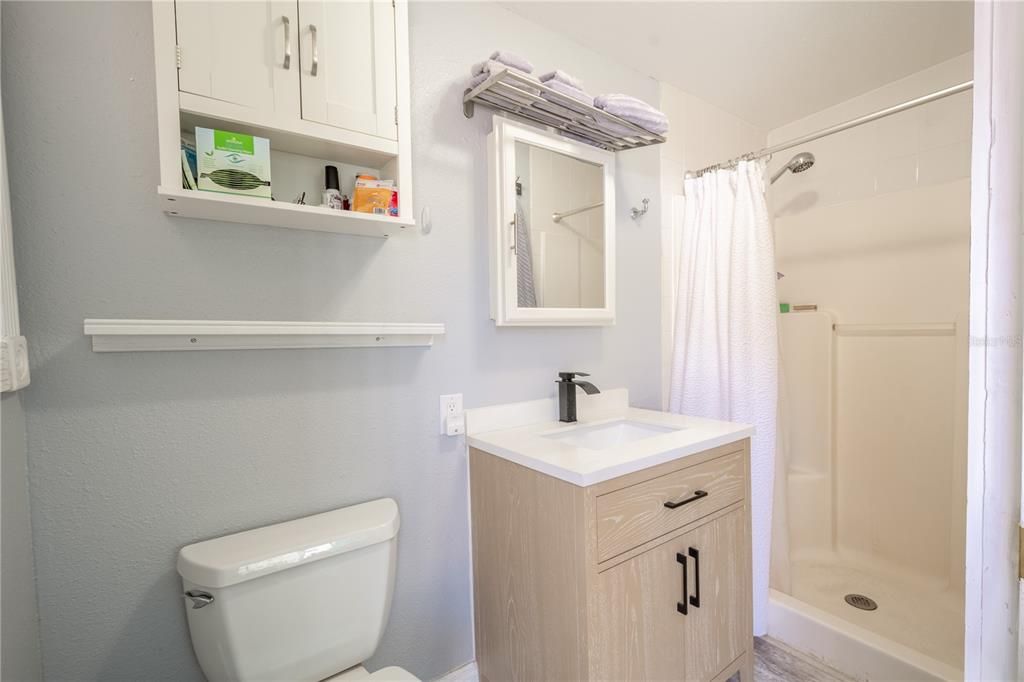Bathroom 2 features a walk-in shower, a mirrored vanity with storage and ceramic tile. flooring.