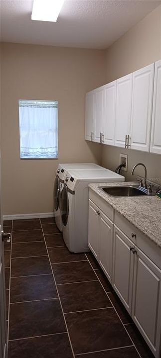 Laundry room with utility sink and cabinets 6614 Sinisi Dr mt dora fl Chesterhill Estates