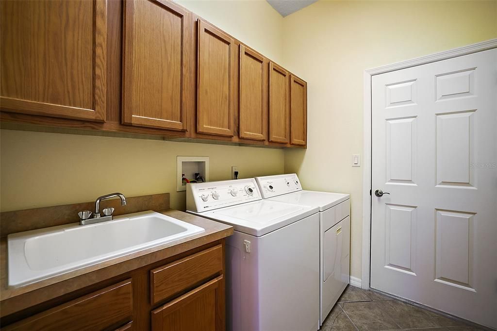 Inside laundry room with storage and a large sink.