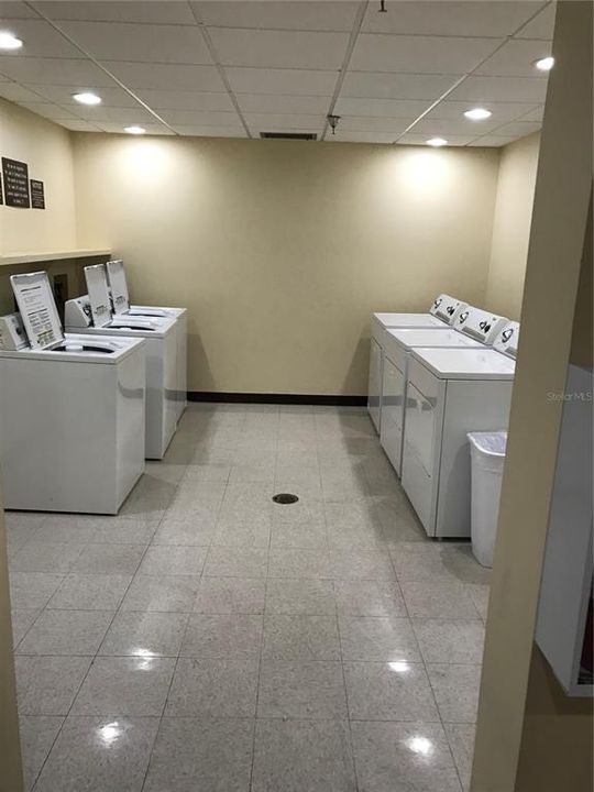 Several washers and dryers in the laundry room.